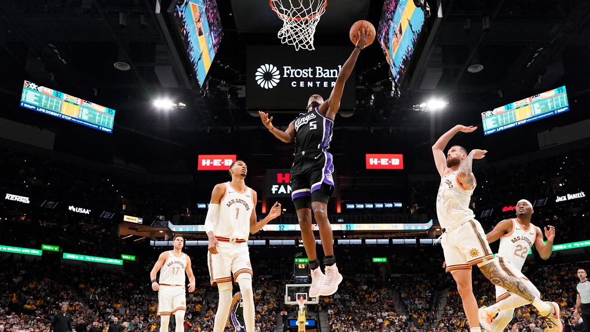 Sacramento Kings Guard De'aaron Fok (5) Drive to the basket between San Antonio Spurs forwards Victor Vembania (1) and Sandro Mamukelashvili (54) during the second half in the center of Mrni Bank. 