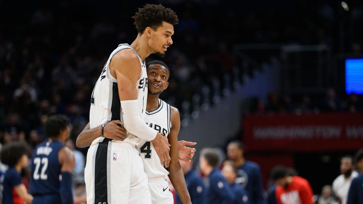 San Antonio Spurs center Victor Wembanyama (1) and guard De'Aaron Fox (4) react during the second quarter against the Washington Wizards at Capital One Arena. 