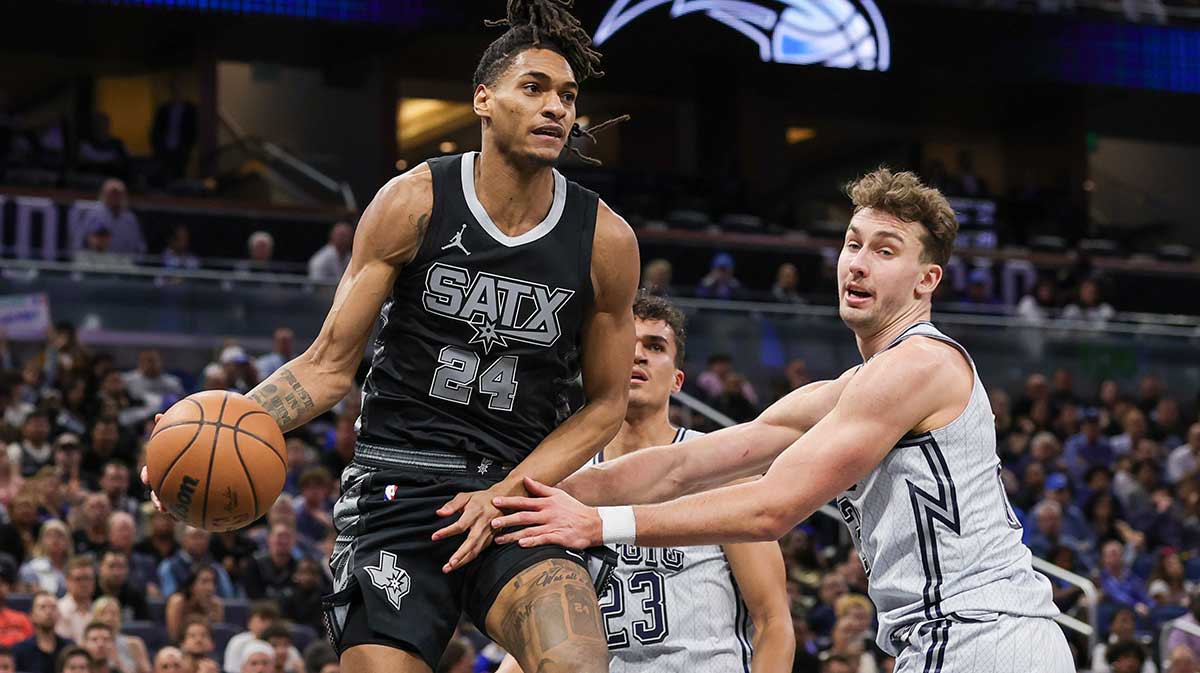 San Antonio Spurs Guard Devin Vassell (24) passes around Orlando Magic Franz Vagner (22) during the second half in the Kia Center. 