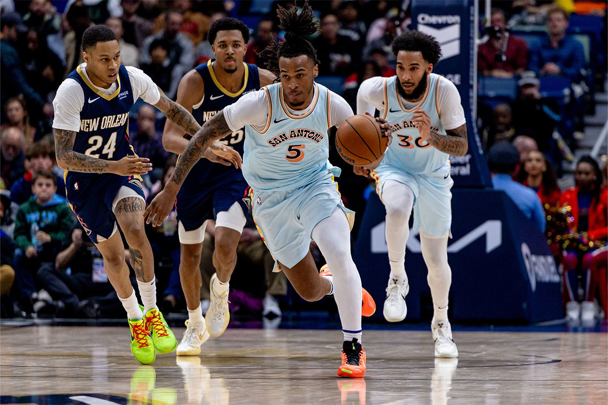 San Antonio Spurs guard Stephon Castle (5) brings the ball up court against New Orleans Pelicans guard Jordan Hawkins (24) during the second half at Smoothie King Center.