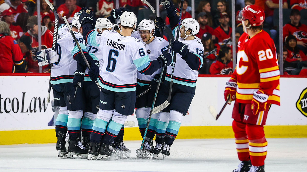 Seattle Kraken center Matty Beniers (10) celebrates his goal with teammates against the Calgary Flames during the overtime period at Scotiabank Saddledome.