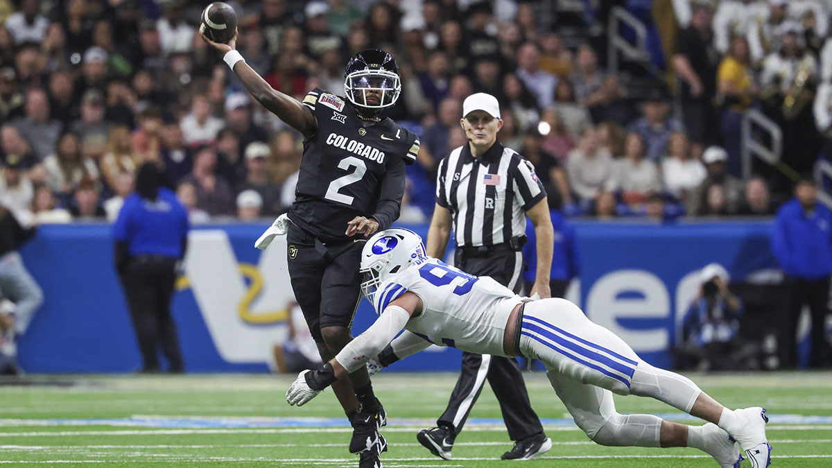 Colorado Buffaloes quarterback Shedeur Sanders (2) attempts a pass as Brigham Young Cougars defensive end Tyler Batty (92) attempts to make a tackle during the third quarter at Alamodome.