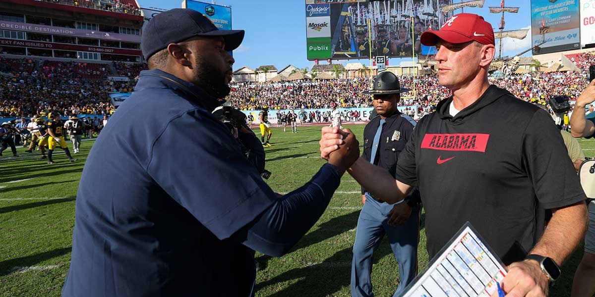 Michigan Wolverines head coach Sherrone Moore greets Alabama Crimson Tide head coach Kalen Deboer after the ReliaQuest Bowl at Raymond James Stadium.