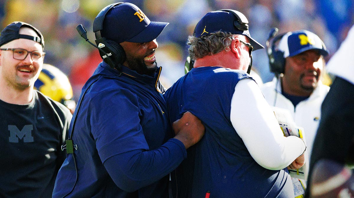Michigan Wolverines head coach Sherrone Moore smiles while joking with a defensive coach against the Alabama Crimson Tide during the second half at Raymond James Stadium.