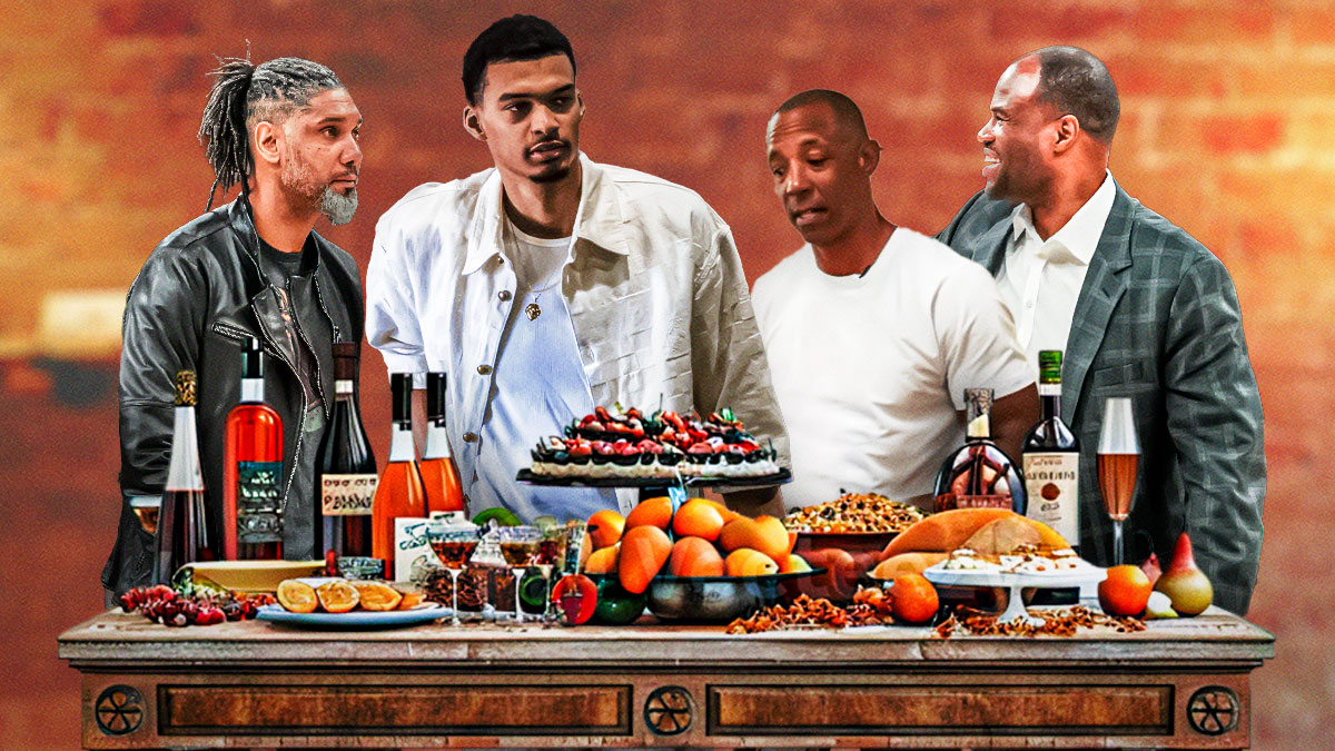 Spurs legend Sean Elliott next to Spurs All-Star Victor Wembanyama, Spurs Hall of Fame center David Robinson, Spurs Hall of Fame forward Tim Duncan sitting together at a dinner table with food spread out