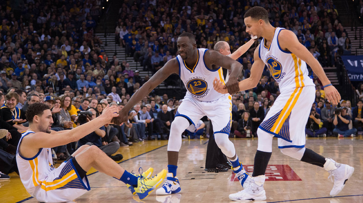 The Golden State Warriors Klay Thompson goalkeeper (11, on the left) is helped by striker Draymond Green (23) and goalkeeper Stephen Curry (30) in the fourth quarter against Miami Heat in Oracle Arena. The Warriors beat the Heat 111-103.