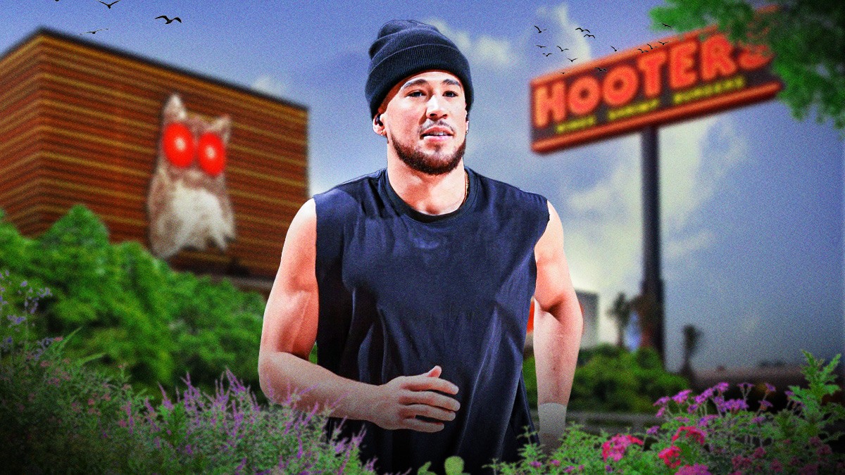 Suns guard Devin Booker in street clothes, with the Hooters restaurant sign above him.