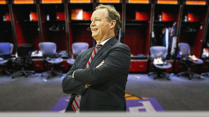 Suns head coach Mike Budenholzer, smiling, with a background of the Suns locker room.