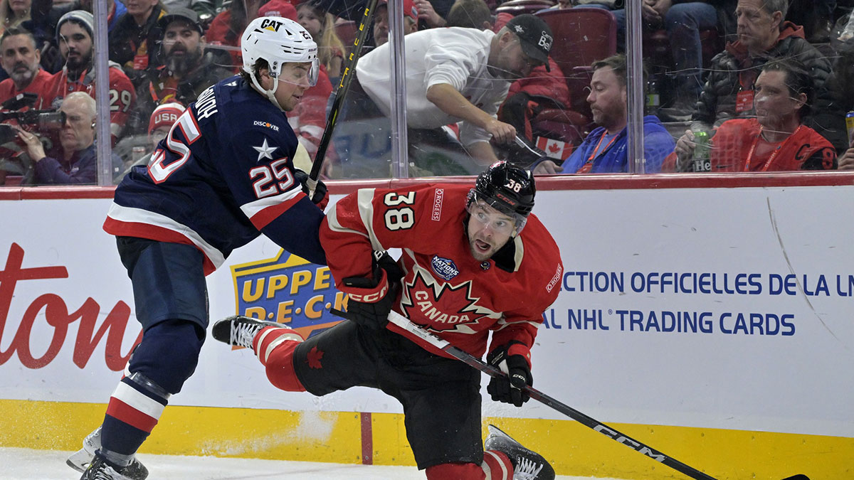 Feb 15, 2025; Montreal, Quebec, CAN; [Imagn Images direct customers only] Team Canada forward brandon Hagel (38) plays the puck and Team United States defenseman Charlie McAvoy (25) defends in the second period during a 4 Nations Face-Off ice hockey game at the Bell Centre.