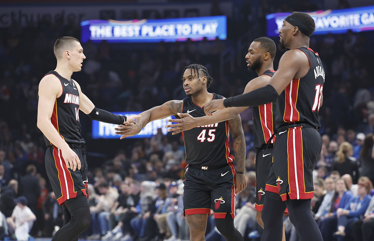 The goalkeeper of Miami Heat Tyler Herro (14), the goalkeeper Davion Mitchell (45), the striker Andrew Wiggins (22) and the Bam Adebayo (13) High five center after a game against Oklahoma City Thunder during the first quarter at the Paycc Center. 