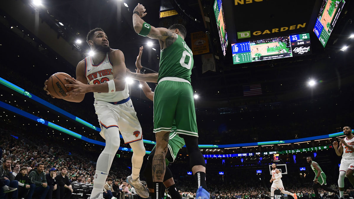  New York Knicks center Karl-Anthony Towns (32) controls the ball while Boston Celtics forward Jayson Tatum (0) defends during the first half at TD Garden