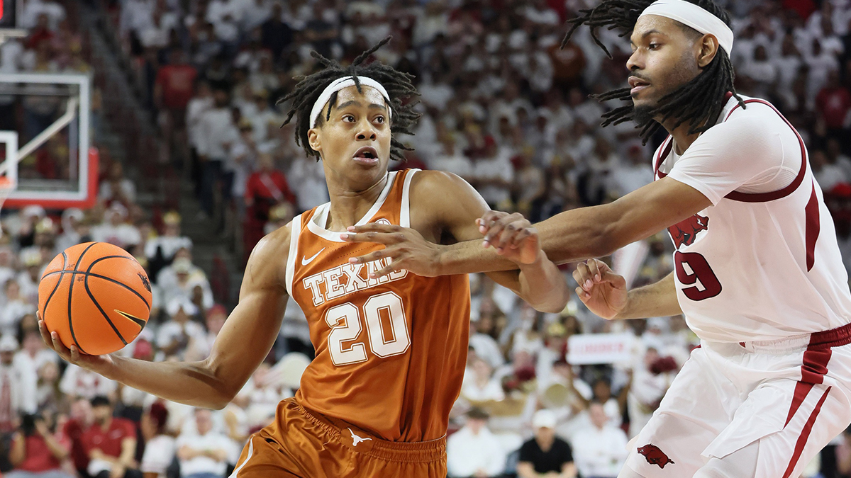 Texas Longhorns guard Tre Johnson (20) drives against Arkansas Razorbacks forward Jonas Aidoo (9) during the second half at Bud Walton Arena.