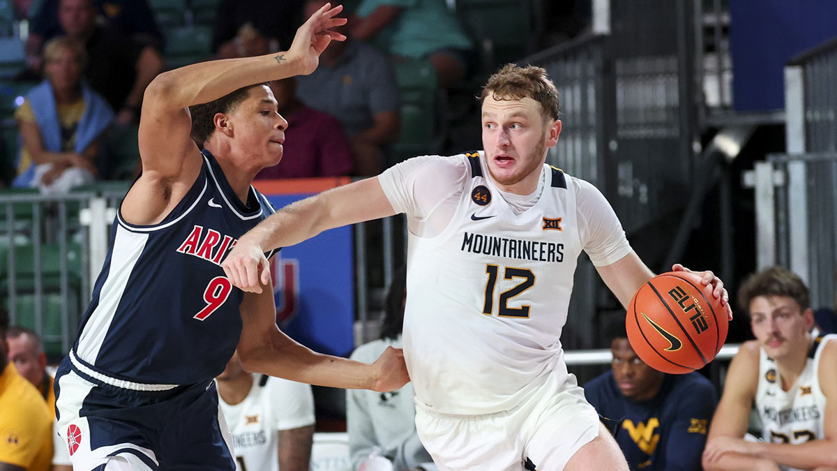 West Virginia Mountaineers guard Tucker DeVries (12) drives to the basket as Arizona Wildcats forward Carter Bryant (9) defends during the second half at Imperial Arena at the Atlantis resort.