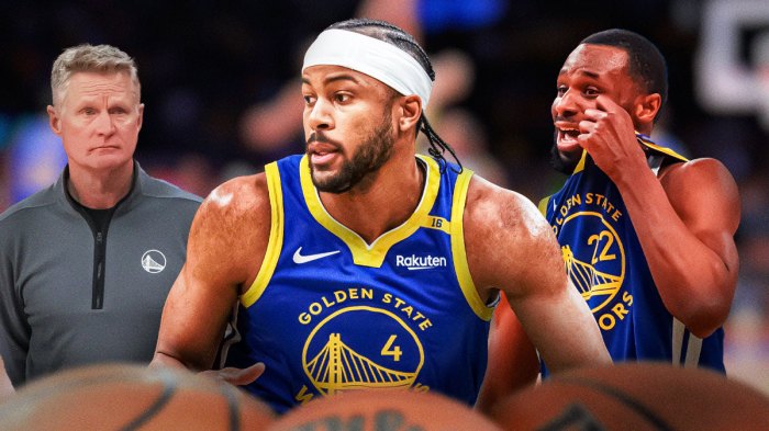 Warriors forward Moses Moody next to former Warriors Andrew Wiggins with Warriors head coach Steve Kerr in the background next to the Warriors logo