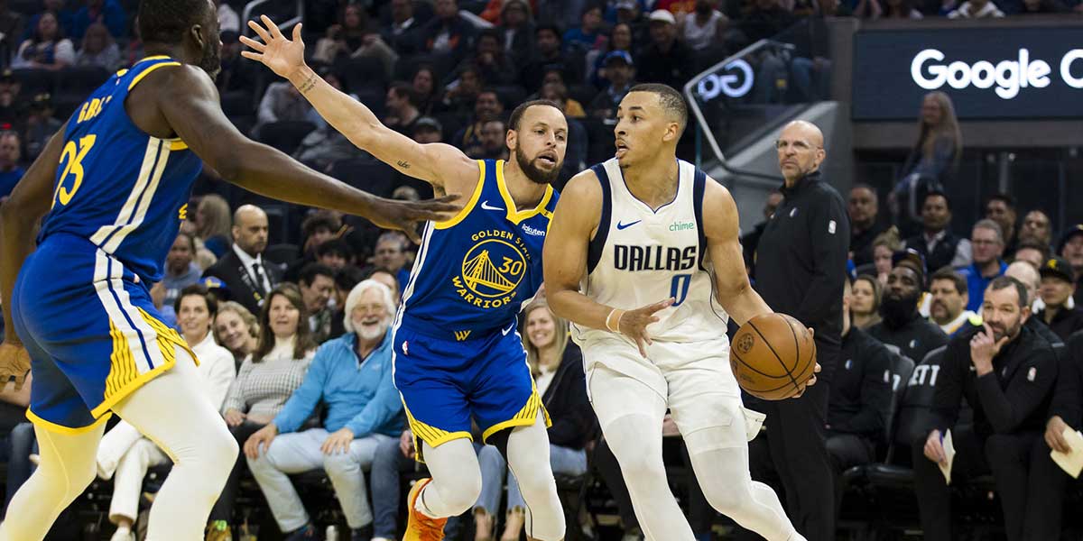 Dallas Mavericks guard Dante Exum (0) drives past Golden State Warriors guard Stephen Curry (30) during the first quarter at Chase Center.