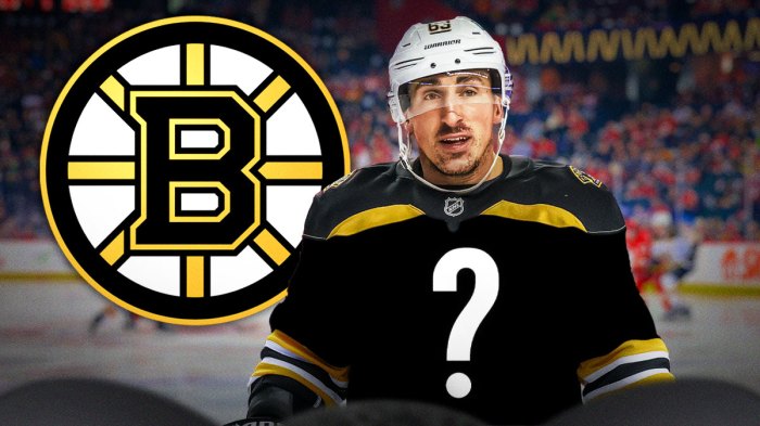 brad marchand in a blank jersey with bruins logo behind him