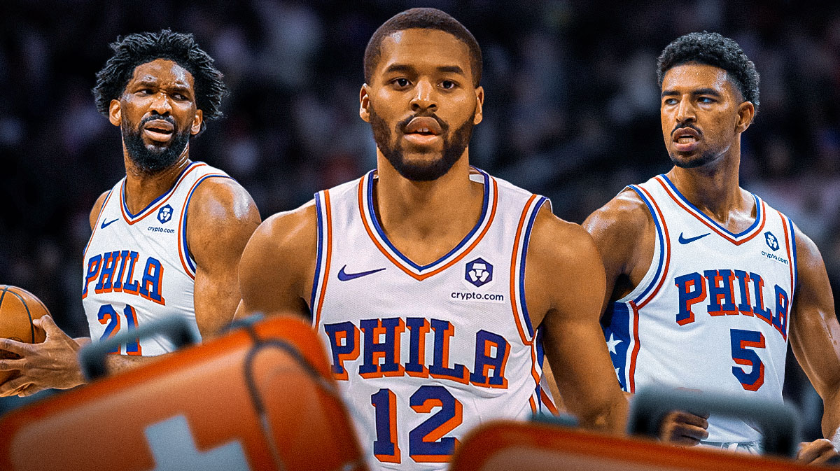 Jared Butler and Quentin Grimes next to Joel Embiid with a medical cross over his jersey number on the 76ers court.