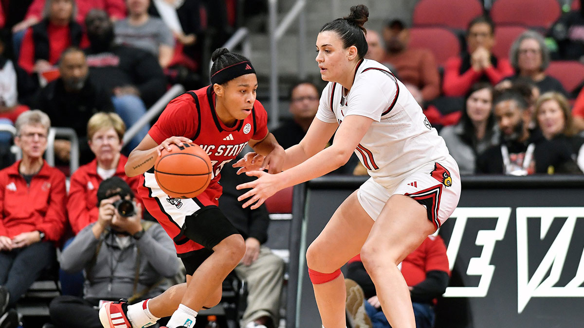 Louisville forward Elif Istanbulluoglu (11) attempts to tip the ball away from NC State guard Zoe Brooks (35) during the first half of an NCAA college basketball game, Sunday, Dec. 15 2024 in Louisville Ky.