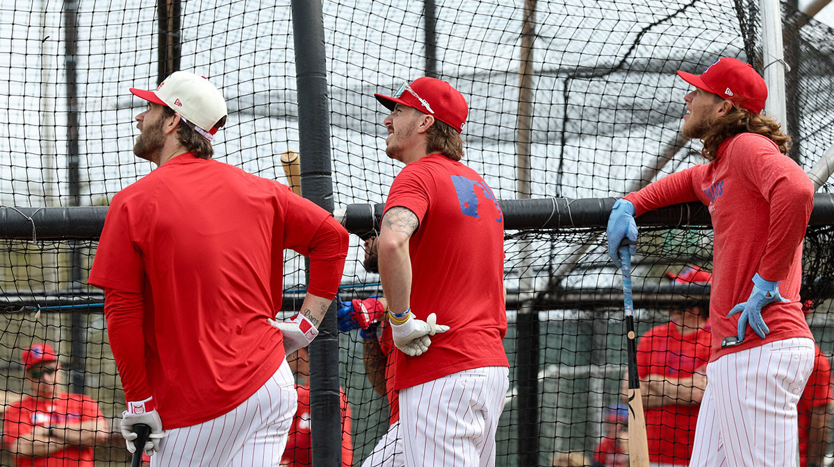 Philadelphia Phillies first base Bryce Harper (3) (left) second base Bryson Stott (5) (center) and Philadelphia Phillies third base Alec Bohm (28) (right) take batting practice during spring training workouts at BayCare Ballpark.