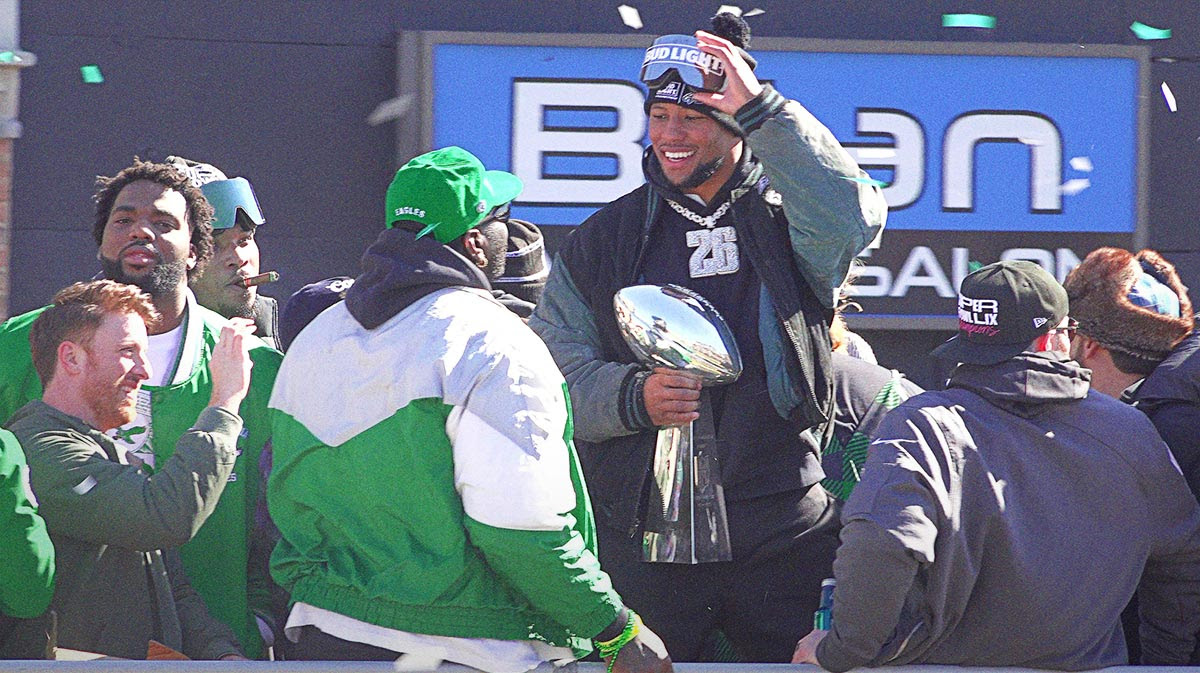 Eagles running back Saquon Barkley (center) holds the Vince Lombardi trophey during the Eagles Super Bowl championship parade on Friday February 14, 2025