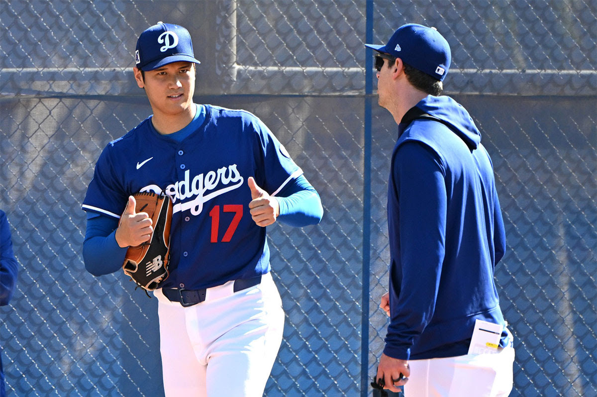 Los Angeles Dodgers designated hitter Shohei Ohtani (17) works with Los Angeles Dodgers assistant pitching coach Connor McGuiness (87) during a spring training bullpen session at Camelback Ranch.