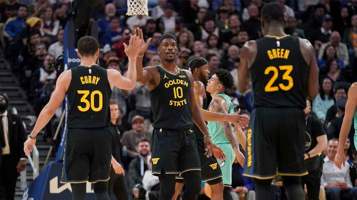 Golden State Warriors forward Jimmy Butler III (10) is congratulated by guard Stephen Curry (30) after a basket against the Charlotte Hornets in the third quarter at the Chase Center.