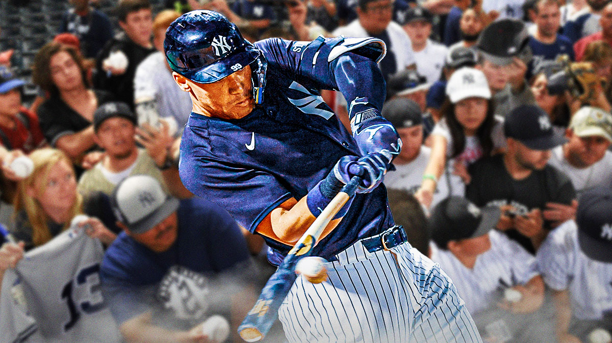 New York Yankees outfielder Aaron Judge swinging a bat in center, excited/happy Yankees fans on left and right sides, George M. Steinbrenner Field (spring training home of the New York Yankees) in background