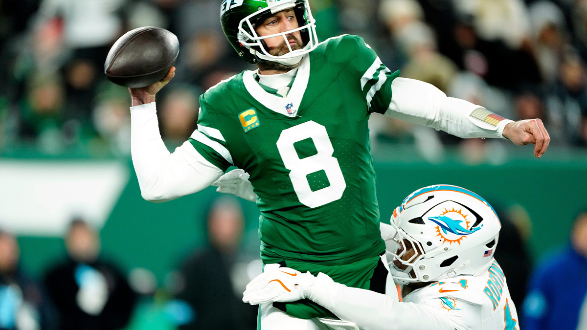 New York Jets quarterback Aaron Rodgers (8) throws a pass before Miami Dolphins linebacker Chop Robinson (44) could take him down, Sunday January 5, 2025, in East Rutherford.