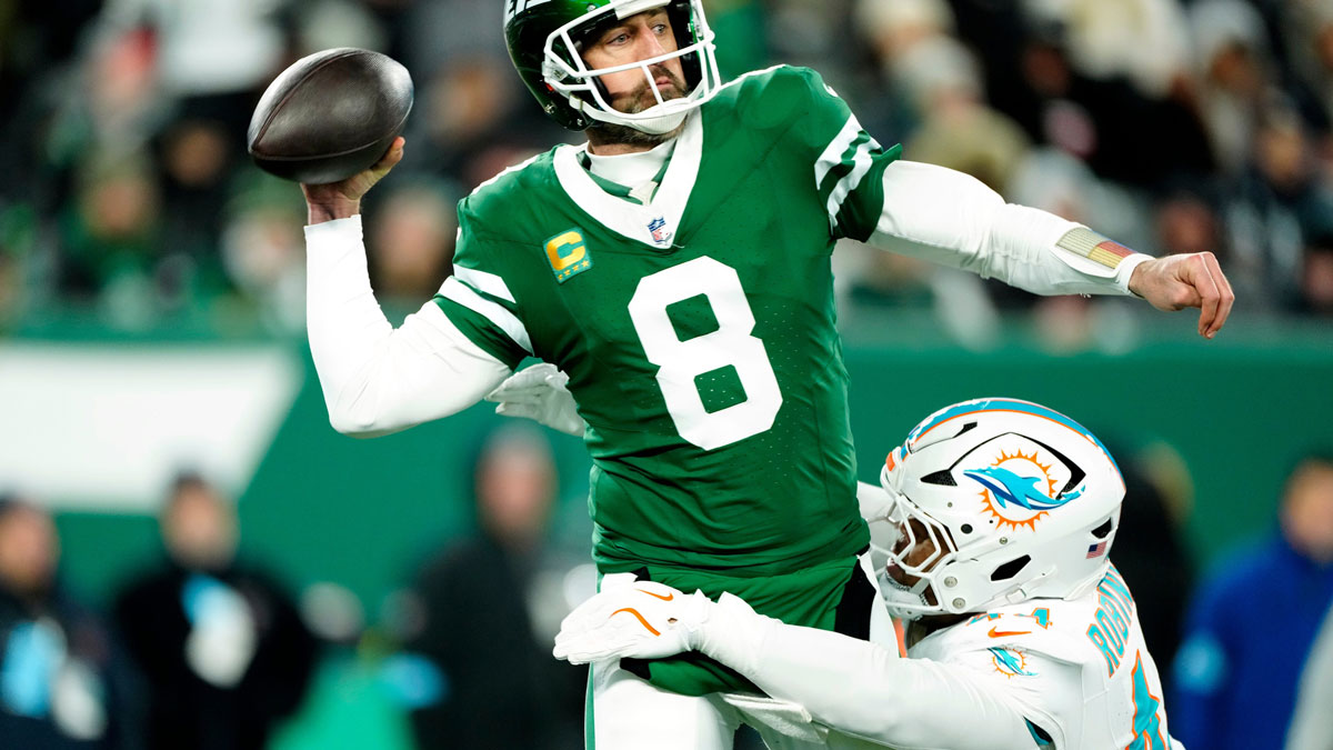 New York Jets quarterback Aaron Rodgers (8) throws a pass before Miami Dolphins linebacker Chop Robinson (44) could take him down, Sunday January 5, 2025, in East Rutherford.