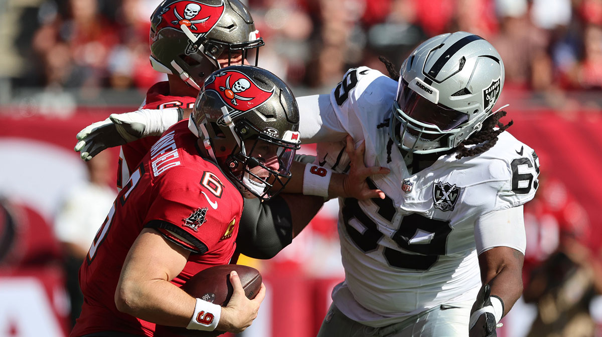 Tampa Bay Buccaneers quarterback Baker Mayfield (6) stiff arms Las Vegas Raiders defensive tackle Adam Butler (69) during the second quarter at Raymond James Stadium. Mandatory Credit: Kim Klement Neitzel-Imagn Images