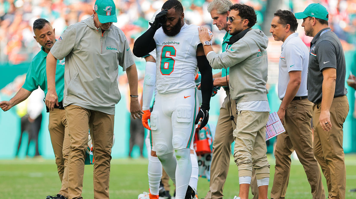 Miami Dolphins linebacker Anthony Walker Jr. (6) is helped off the field by trainers and head coach Mike McDaniel against the New England Patriots during the second quarter at Hard Rock Stadium.