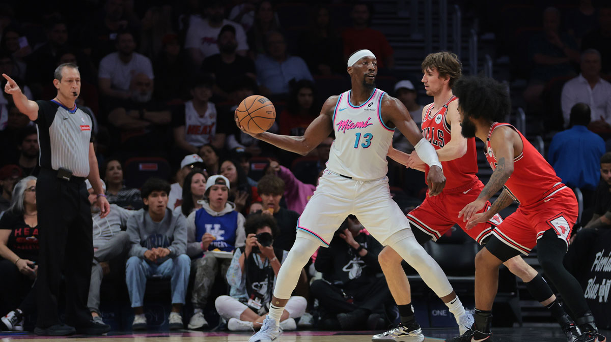 迈阿密热火中心Bam Adebayo（13）在第一节在Kaseya中心保护篮球免受芝加哥公牛的前锋Matas Buzelis（14）和后卫Coby White（0）的保护。