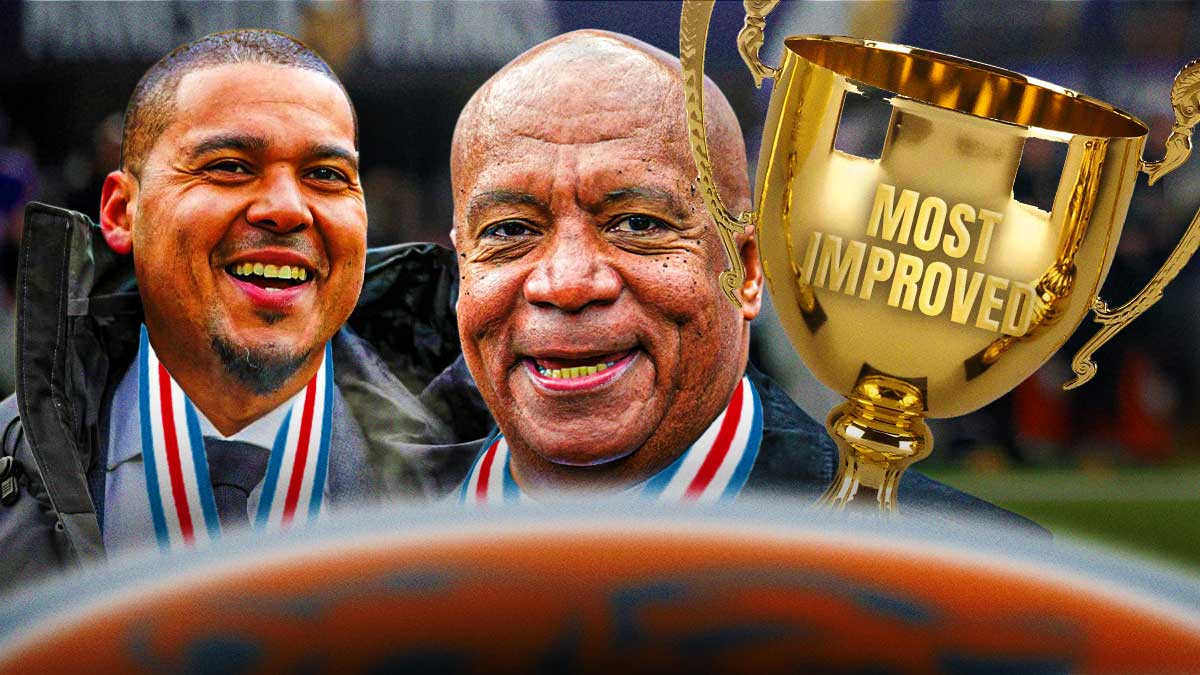 Bears GM Ryan Poles and team president Kevin Warren smiling/happy while wearing medals around their necks and holding a trophy that says "Most Improved" after the first day of free agency. Background is Soldier Field.
