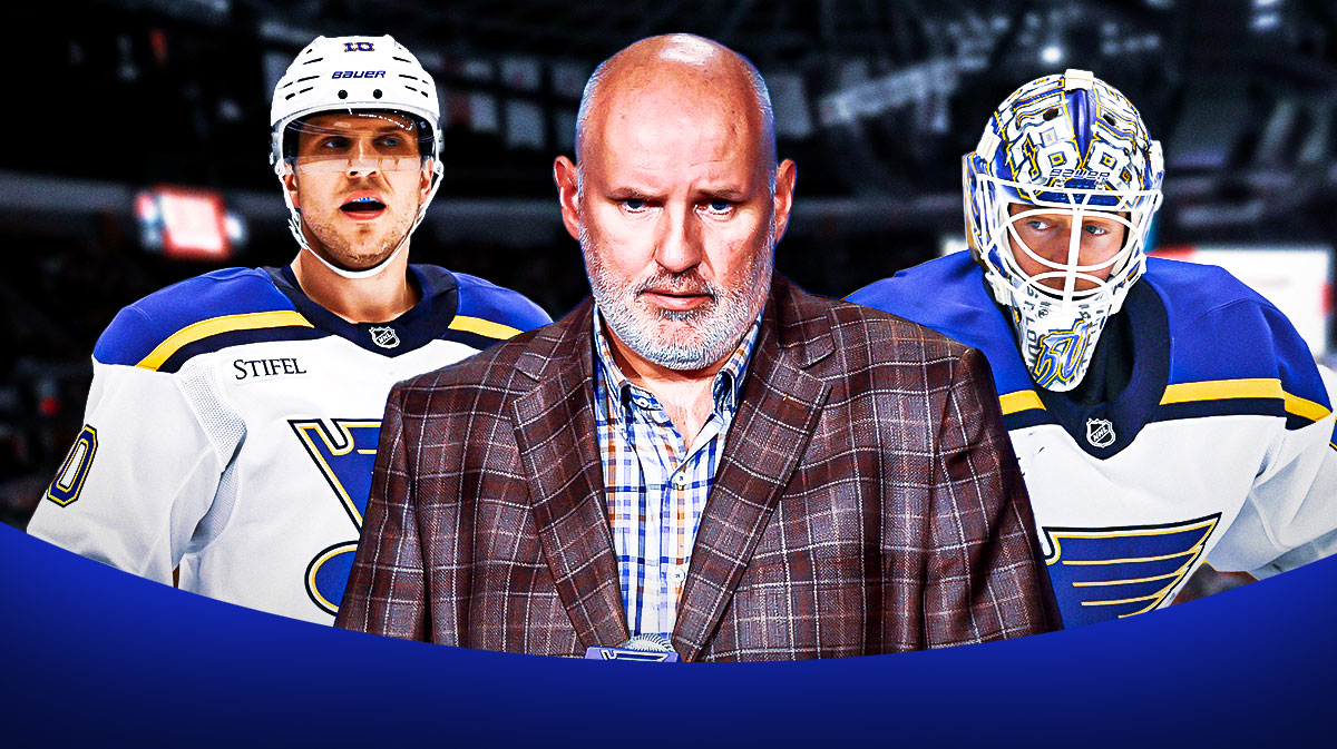 Jordan Binnington, Brayden Schenn in Blues uniforms and Doug Armstrong in a suit in front of Blues logo and ice rink.