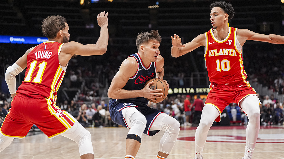 LA Clippers guard Bogdan Bogdanovic (10) handles the ball between Atlanta Hawks guard Trae Young (11) and forward Zaccharie Risacher (10) during the second half at State Farm Arena.