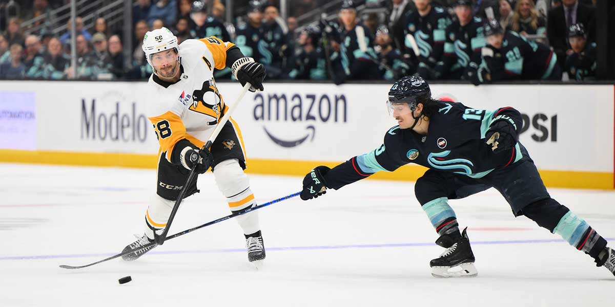 Pittsburgh Penguins defenseman Kris Letang (58) passes the puck past Seattle Kraken left wing Brandon Tanev (13) during the second period at Climate Pledge Arena. 