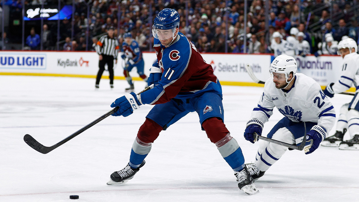 Colorado Avalanche center Brock Nelson (11) controls the puck ahead of Toronto Maple Leafs left wing Scott Laughton (24) in the first period at Ball Arena.