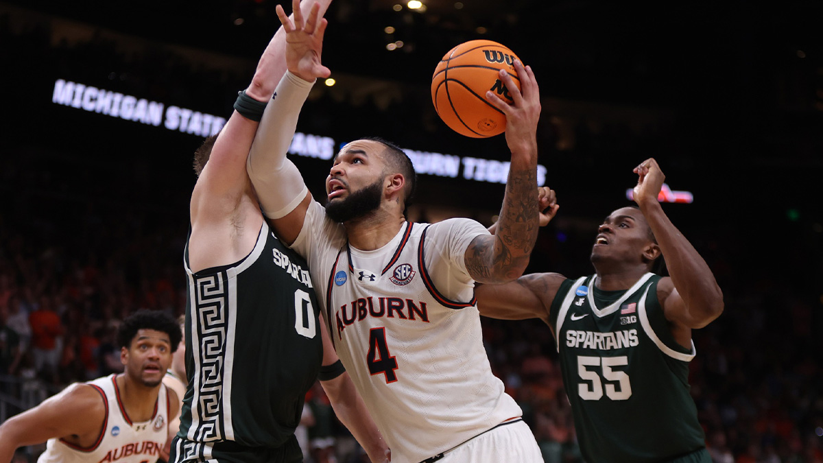 Auburn Tigers forward Johni Broome (4) drives against Michigan State Spartans forward Jaxon Kohler (0) and forward Coen Carr (55) during the first half in the South Regional final of the 2025 NCAA tournament at State Farm Arena. Mandatory Credit: Brett Davis-Imagn Images