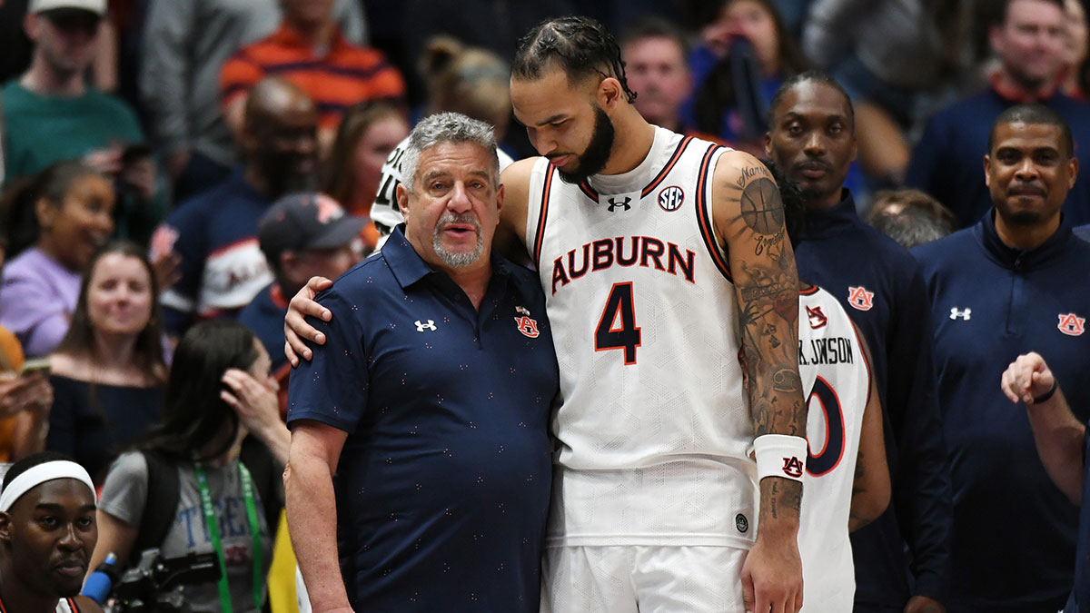 Auburn Tigers forward Johni Broome (4) embraces head coach Bruce Pearl in the second half against the Florida Gators in the SEC Tournament championship game at Bridgestone Arena.
