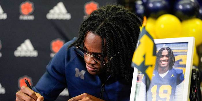 Michigan football signee Bryce Underwood poses for a photo as he signs for Michigan football on during national signing day at Belleville High School