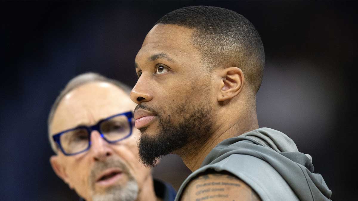 Bucks guard Damian Lillard (right) chats up Golden State Warriors assistant coach Ron Adams before a game at Chase Center