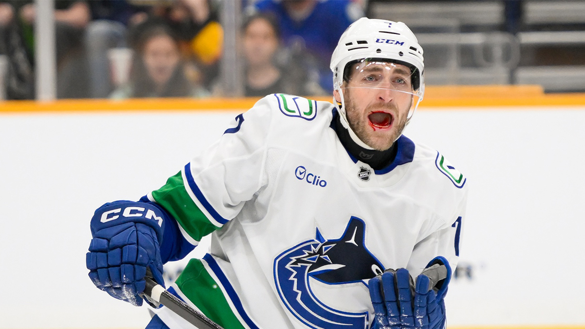 Vancouver Canucks defenseman Carson Soucy (7) takes a shot to the mouth against the Nashville Predators during the second period at Bridgestone Arena. 