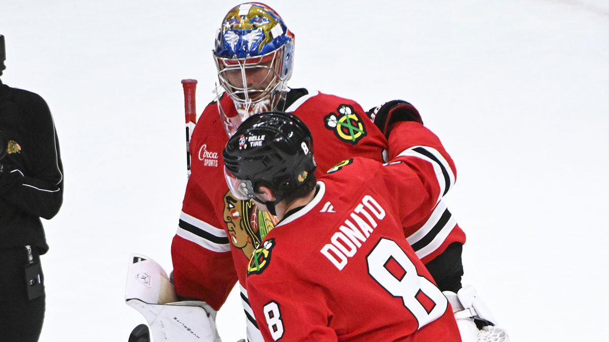 Chicago Blackhawks center Ryan Donato (8) hugs goaltender Spencer Knight after the third period against the Los Angeles Kings at the United Center.