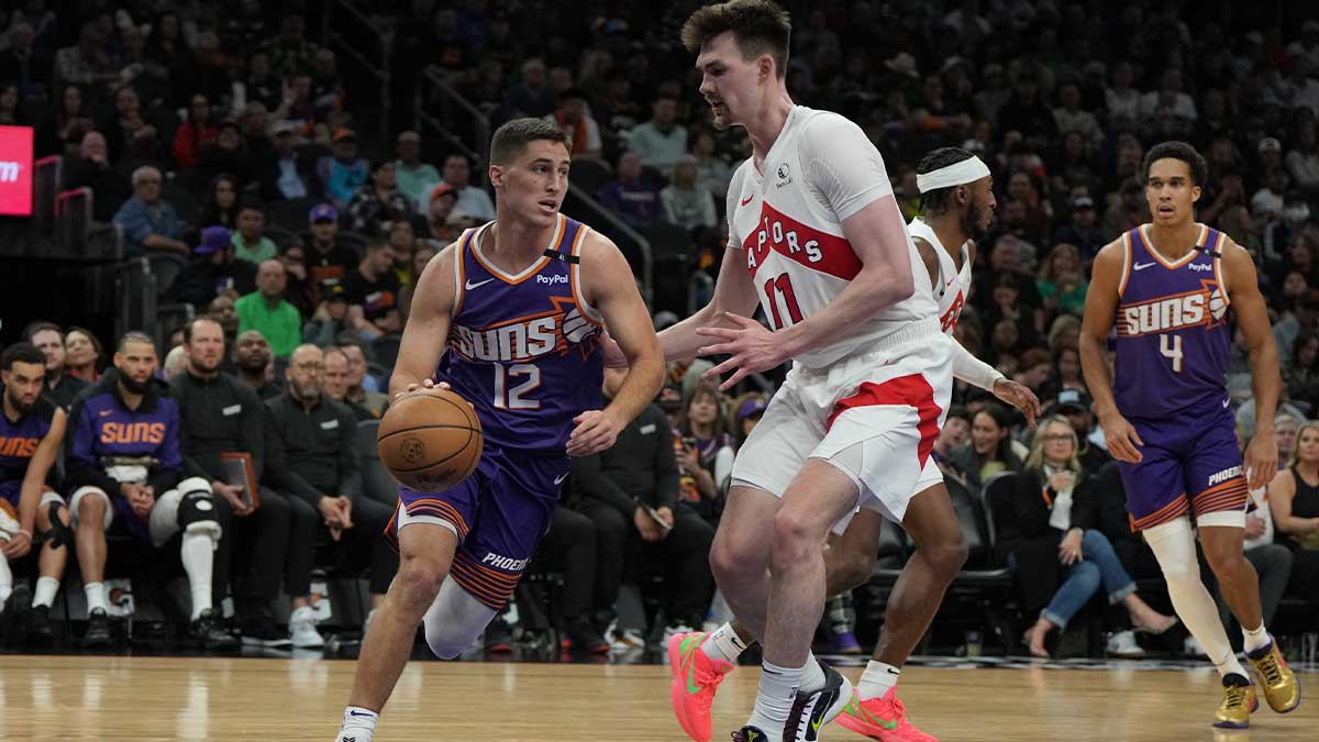 Phoenix Suns guard Collin Gillespie (12) drives on Toronto Raptors center Colin Castleton (11) in the second half at Footprint Center.