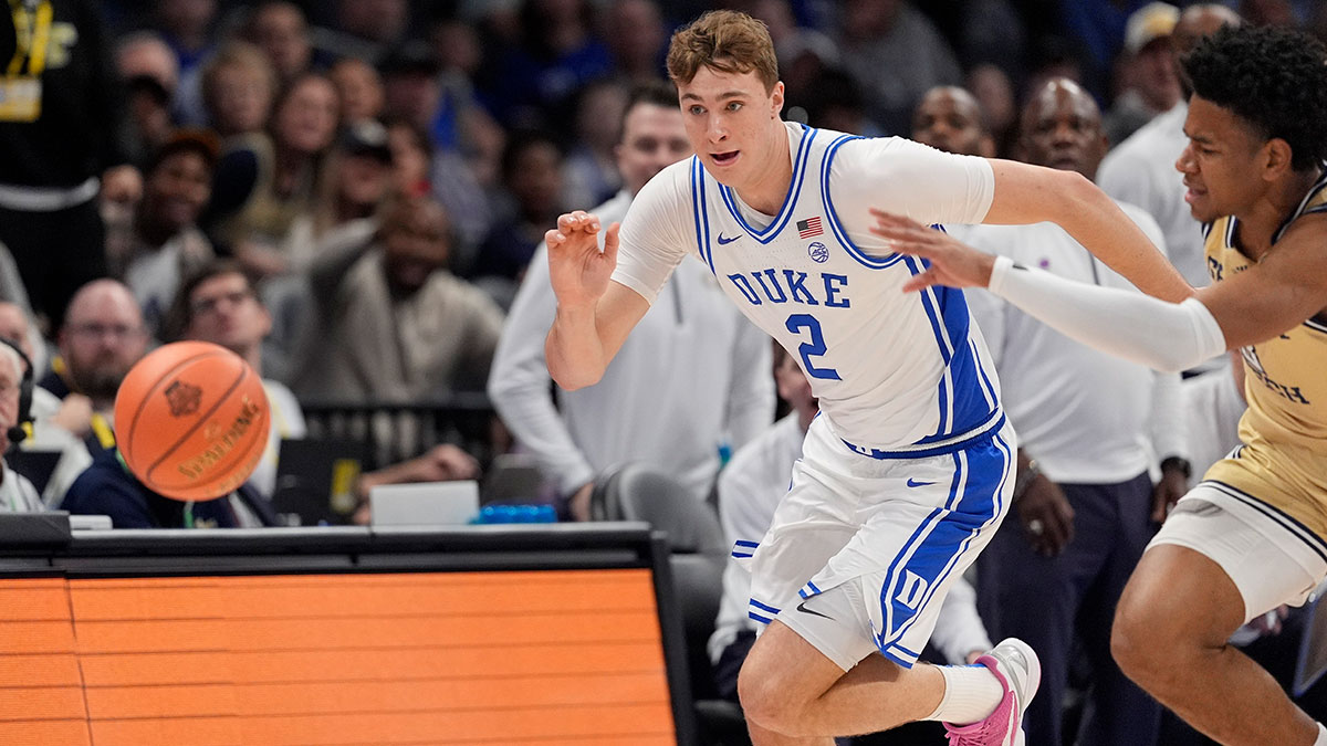 Duke Blue Devils forward Cooper Flagg (2) and Georgia Tech Yellow Jackets guard Jaeden Mustaf (3) chase the loose ball during the first half at Spectrum Center.
