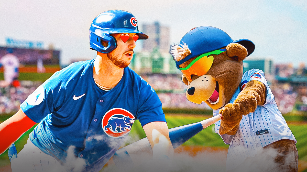 Kyle Tucker in a Chicago Cubs uniform with hearts in his eyes looking at the Cubs' mascot is Clark the Cub as Tucker is happy to be in chicago after being traded by the houston astros this offseason.