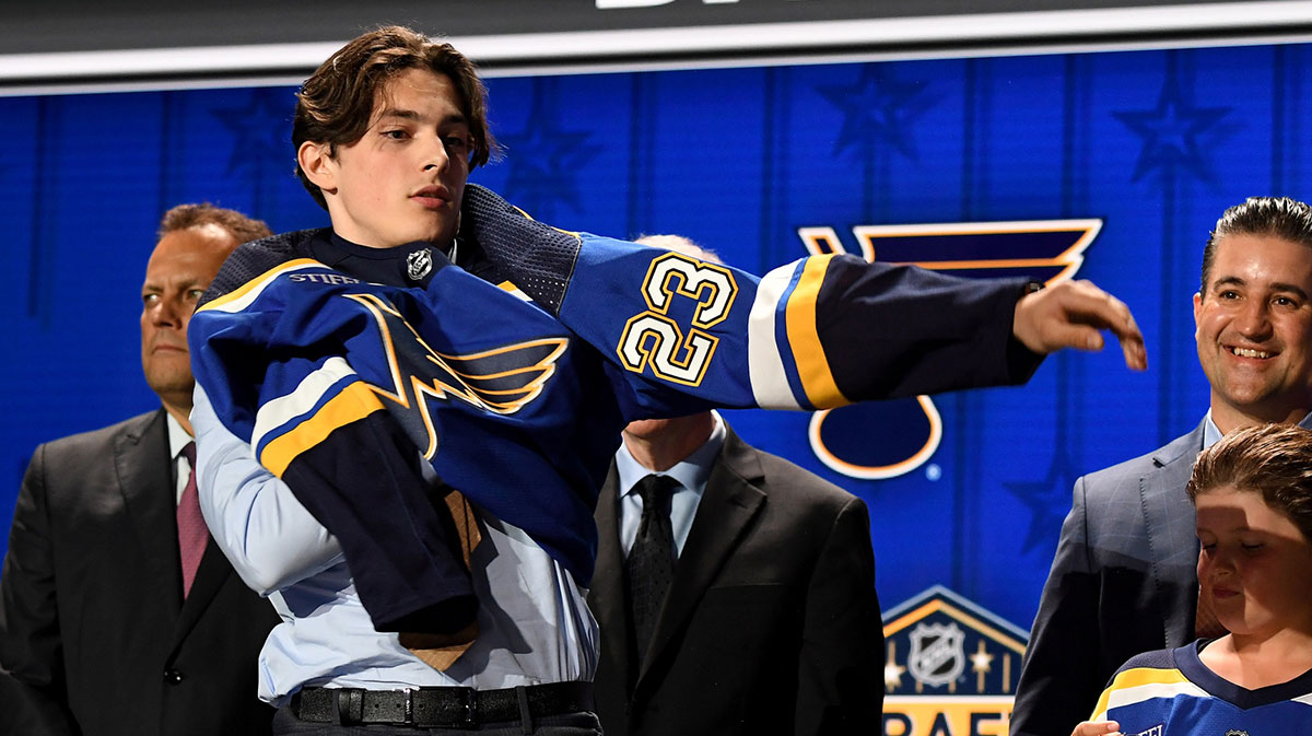 St. Louis Blues draft pick Dalibor Dvorsky puts on his sweater after being selected with the tenth pick in round one of the 2023 NHL Draft at Bridgestone Arena.