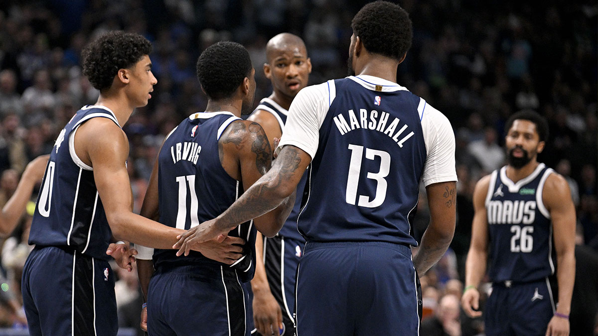 Dallas Mavericks guard Max Christie (00) and forward Naji Marshall (13) and forward Kai Jones (23) and guard Spencer Dinwiddie (26) check on guard Kyrie Irving (11) after he is injured against the Sacramento Kings during the second quarter at the American Airlines Center.