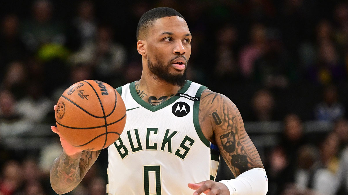 Milwaukee Bucks guard Damian Lillard (0) dribbles the ball against the Los Angeles Lakers in the first quarter at Fiserv Forum. The Bucks wore a small patch to honor former player Junior Bridgeman who passed away this week.