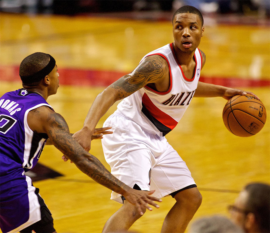 Portland Trail Blazers point guard Damian Lillard (0) looks to pass around Sacramento Kings point guard Isaiah Thomas (22) at the Rose Garden.
